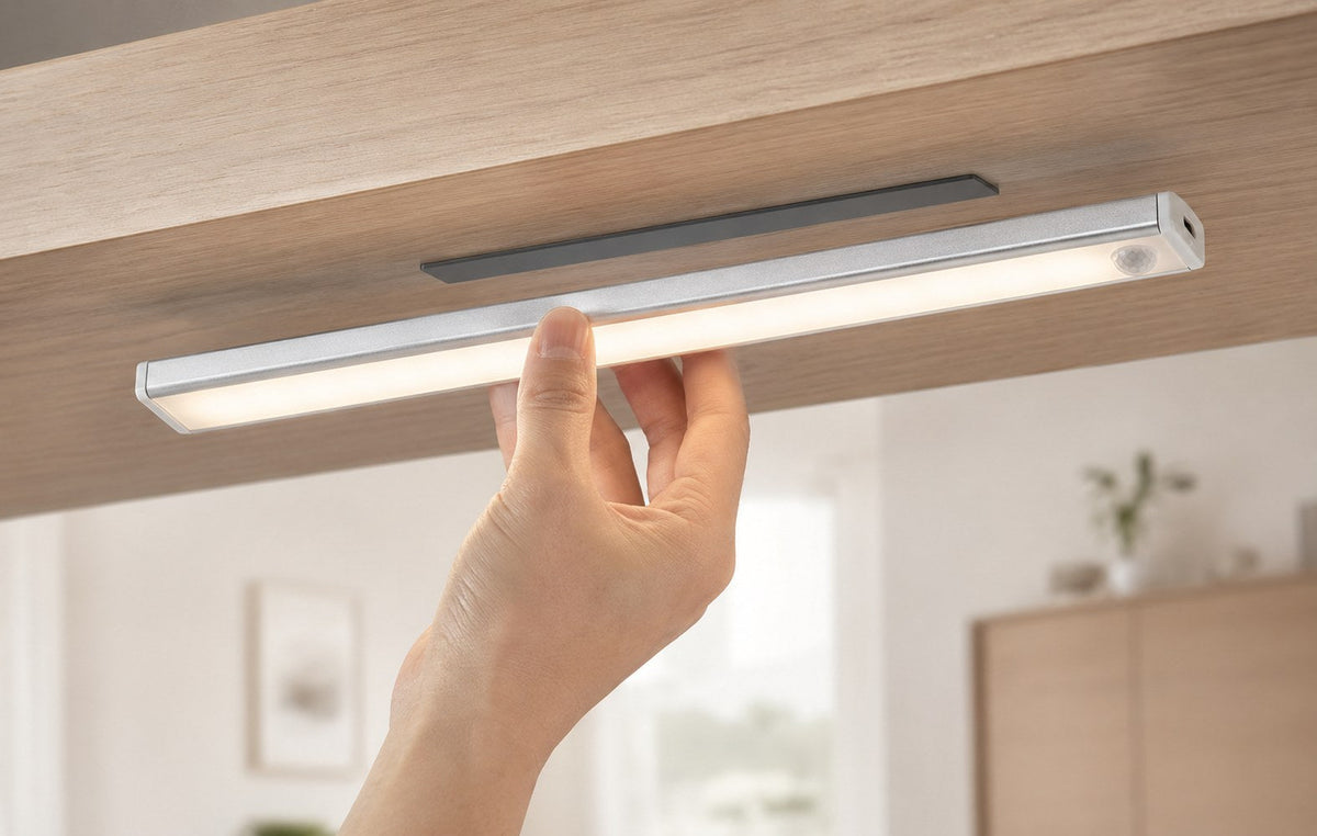 Hand mounting the Dwellio light under a light oak kitchen cabinet with no tools or drilling